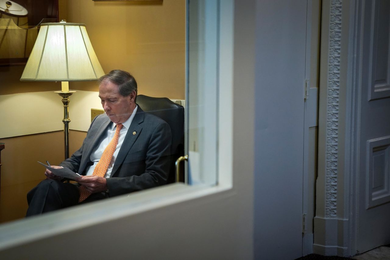 Sen. Tom Udall looks over notes before a news conference January 23.