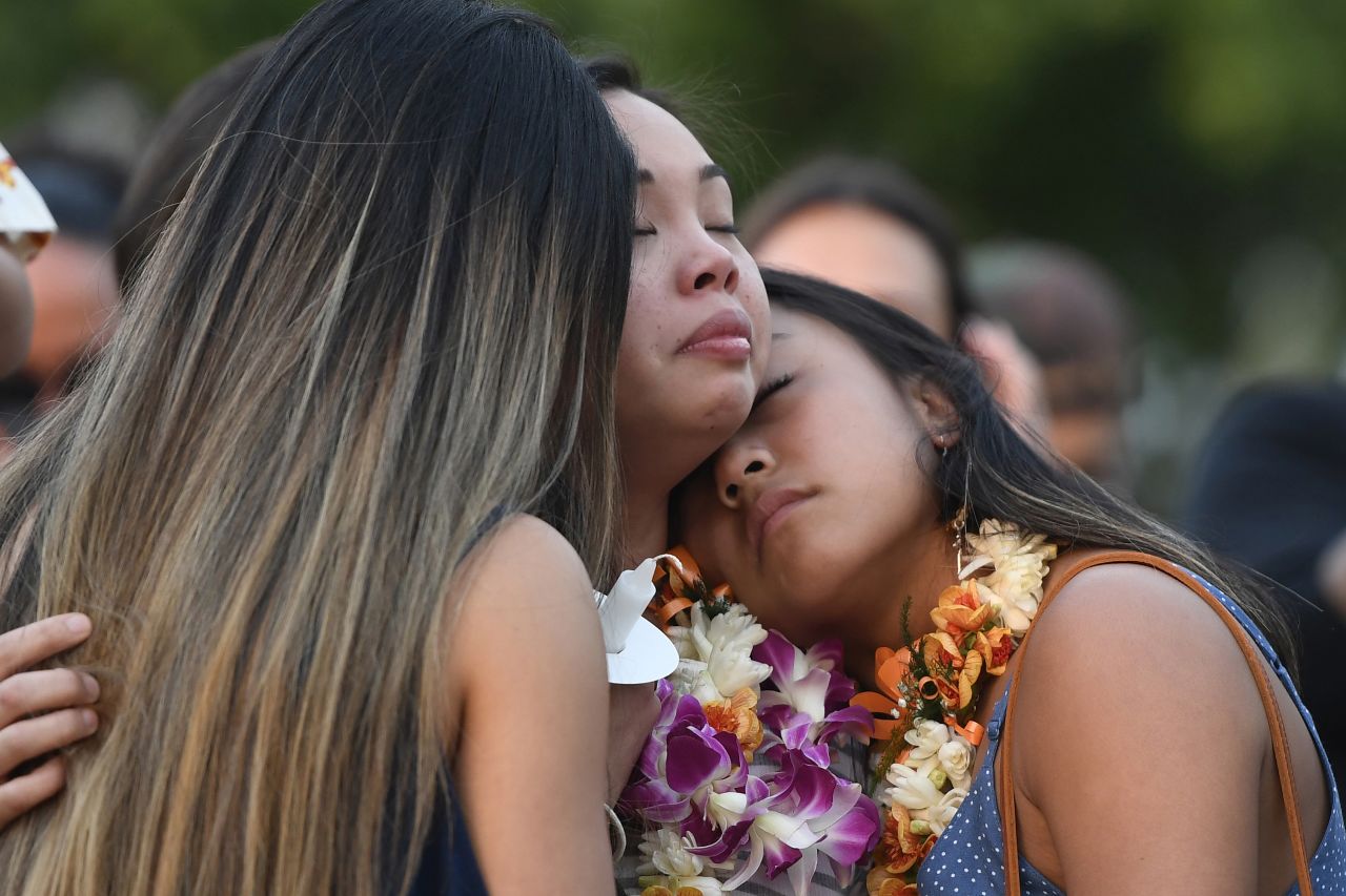 Teiya Enriquez Sandoval, center, and her sister Jazzy Enriquez, right, the daughters of Honolulu Police Officer Tiffany Enriquez, hug family friend Tristel Tynanaes at a candlelight vigil in honor of their mother in Honolulu on Tuesday, January 21. Tiffany Enriquez was one of two Honolulu police officers <a href="https://www.cnn.com/2020/01/19/us/active-shooter-honolulu-hawaii/index.html" target="_blank">shot and killed</a> Sunday when they responded to a call for help in Waikiki.