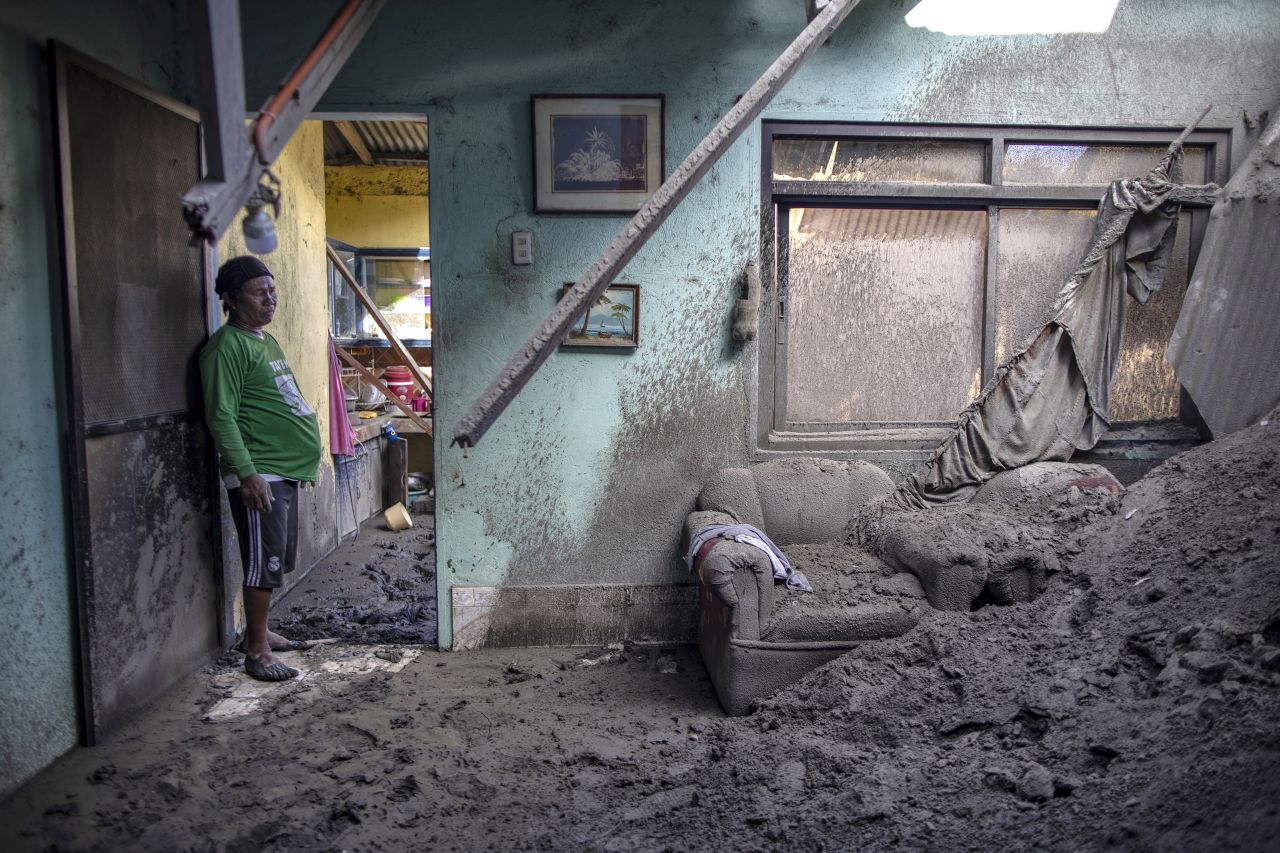 Alex Polopot stands in the living room of his house in the village of Buso-Buso in the Philippines after his roof collapsed due to heavy volcanic ash from <a href="https://www.cnn.com/2020/01/12/asia/gallery/taal-volcano-eruption/index.html" target="_blank">the Taal volcano</a> on Monday, January 20. 