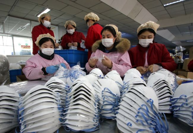 Workers manufacture protective face masks at a factory in China's Hubei Province on January 23, 2020.