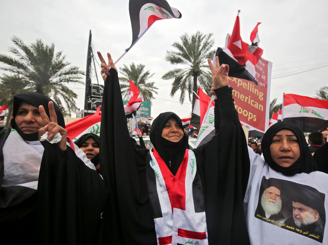 Um Ali wears a shirt with a photograph of Grand Ayatollah Mohammed Sadeq al-Sadr, a Shiite Muslim cleric assassinated during the late Iraqi president Saddam Hussein's rule, and Moqtada Sadr.