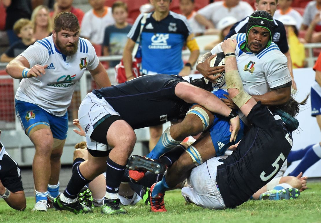 Mbanda is tackled by Scotland's Ben Tools (right).