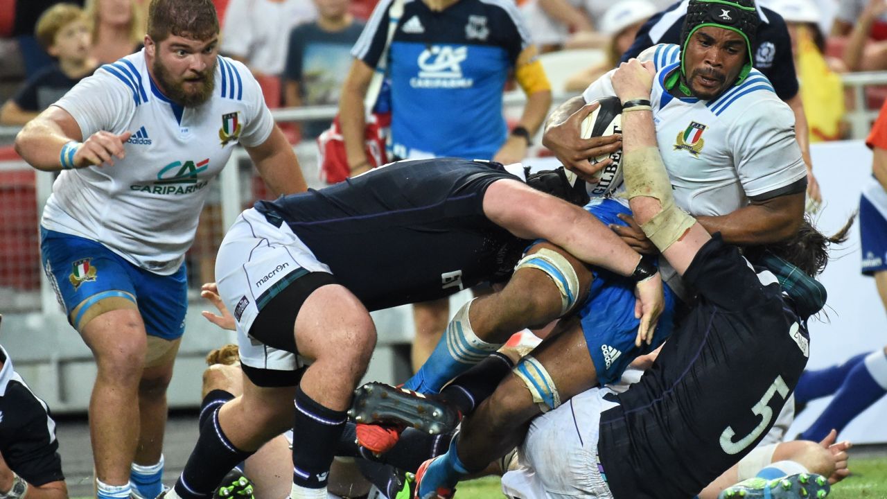 Mbanda is tackled by Scotland's Ben Tools (right).