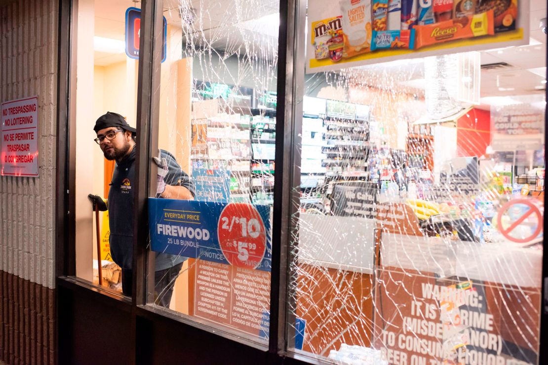 A gasoline station attendant in Houston cleans up broken glass after Friday's explosion. 