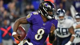 BALTIMORE, MARYLAND - JANUARY 11:  Quarterback Lamar Jackson #8 of the Baltimore Ravens carries the ball against the defense of the Tennessee Titans during the AFC Divisional Playoff game at M&T Bank Stadium on January 11, 2020 in Baltimore, Maryland. (Photo by Will Newton/Getty Images)