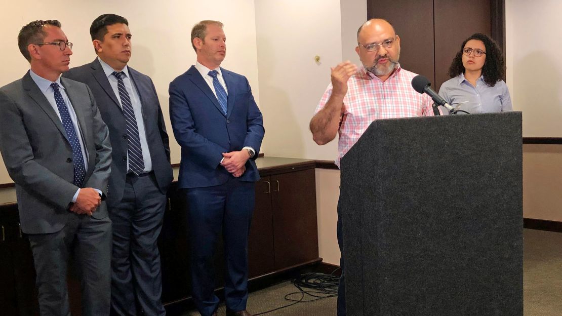 Pastor Angel Campos, at the podium in June 2019, said he felt afraid after the two groups protested at his church over its aiding of  families who had recently arrived at the southern border. 