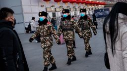 Chinese police officers wear protective masks as they patrol before the annual Spring Festival at a Beijing railway station on January 23, 2020 in Beijing, China. 