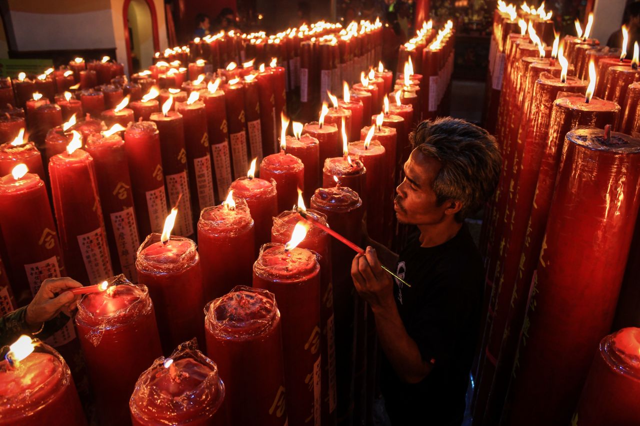 A man lights candles during midnight Lunar New Year celebrations at Dharma Ramsi Temple in Bandung, Indonesia, on January 25.
