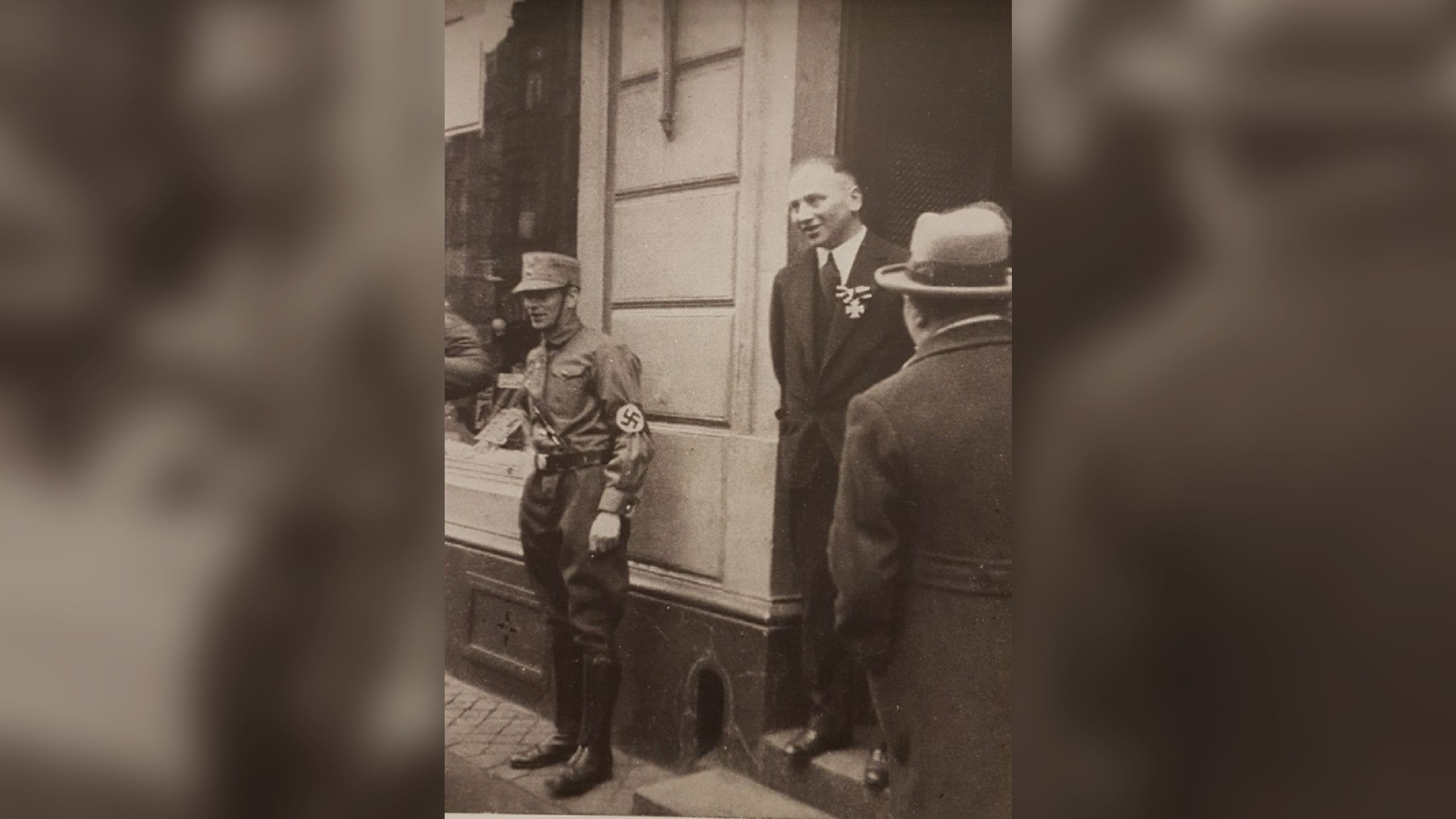 The notorious 1933 image shows Richard Stern, center, wearing his Iron Cross while a young Nazi guards the store.