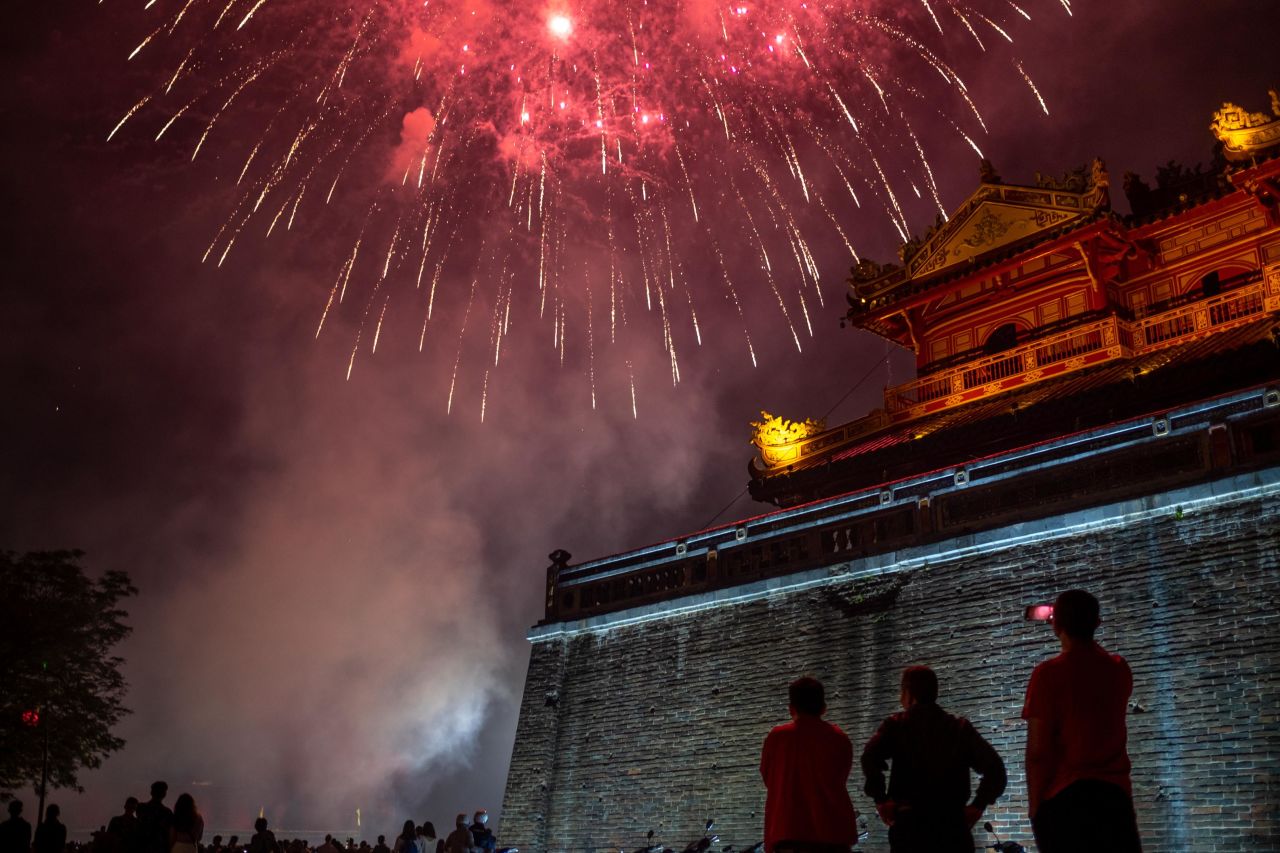 People watch the fireworks display in front of the Imperial City of Hue to mark the Lunar New Year or Tet celebrations in Hue, Vietnam.