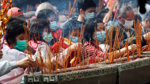 People burn joss sticks as they pray at the Wong Tai Sin Temple in Hong Kong on Saturday, January 25.