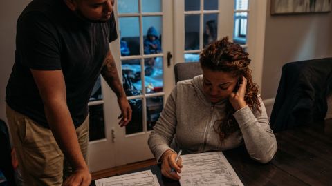 Hernan Cortés Quiles, 37, left, helps sister Sharon Quiñones, 46, fill out an application for a Social Security card to replace the one she left behind on the island.