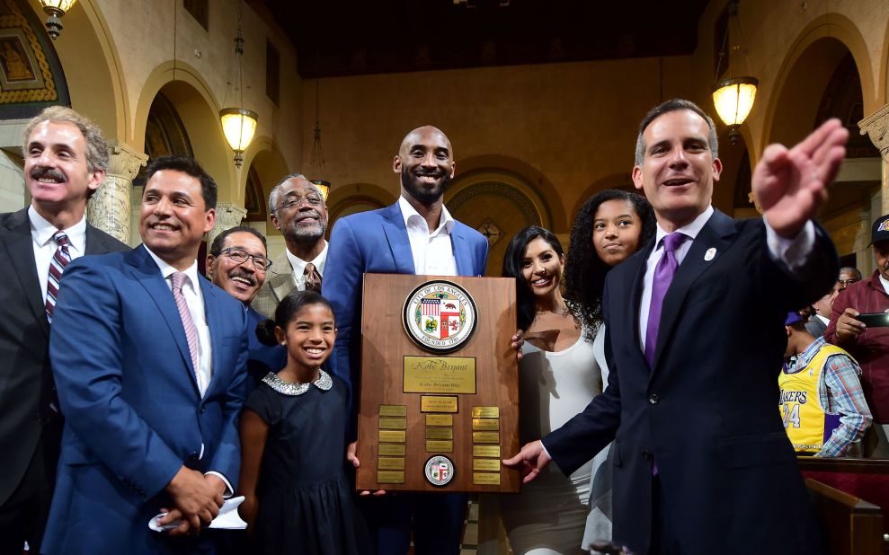 Los Angeles Mayor Eric Garcetti, right, gestures while posing with Bryant alongside members of his family and city officials in 2016. The city council announced August 24 as Kobe Bryant Day. The date commemorates the numbers Bryant wore as a Laker: 8 and 24.