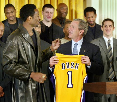 President Bush holds up a Lakers jersey that Bryant gave him at a ceremony for the 2001 NBA World Champions in the East Room of the White House in January 2002.