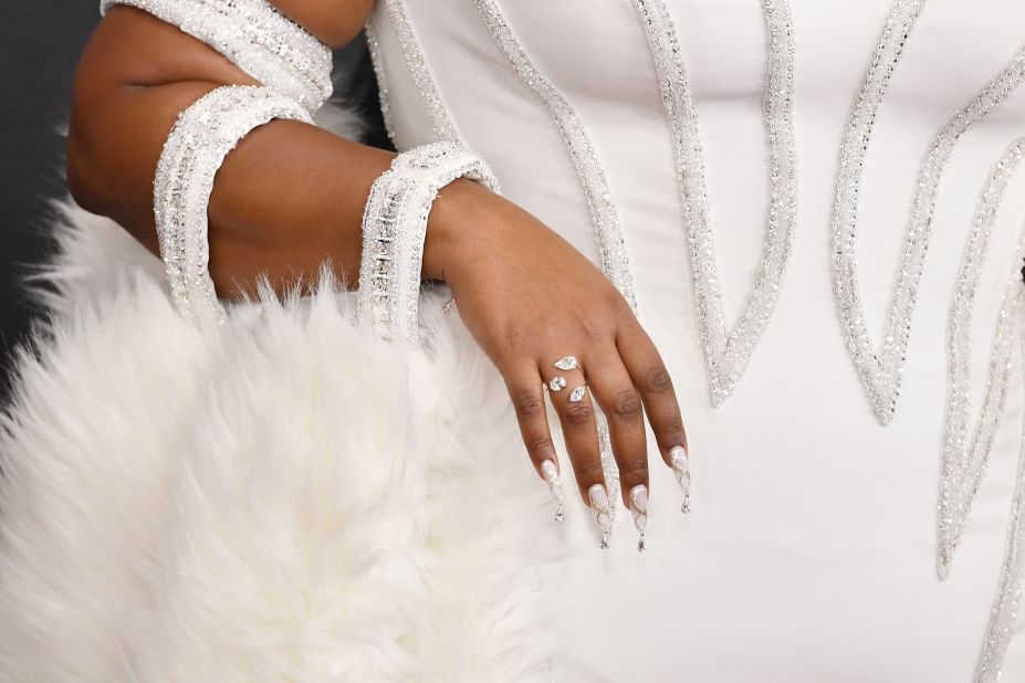 Lizzo's sparkly white ensemble was complemented with a white shawl and elaborate nail art.