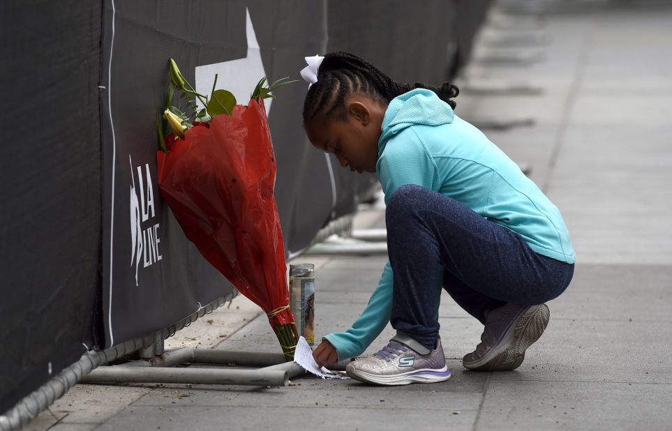 Dharma Brown, 8, writes a note to the late Bryant outside of the Staples Center in Los Angeles on Sunday.