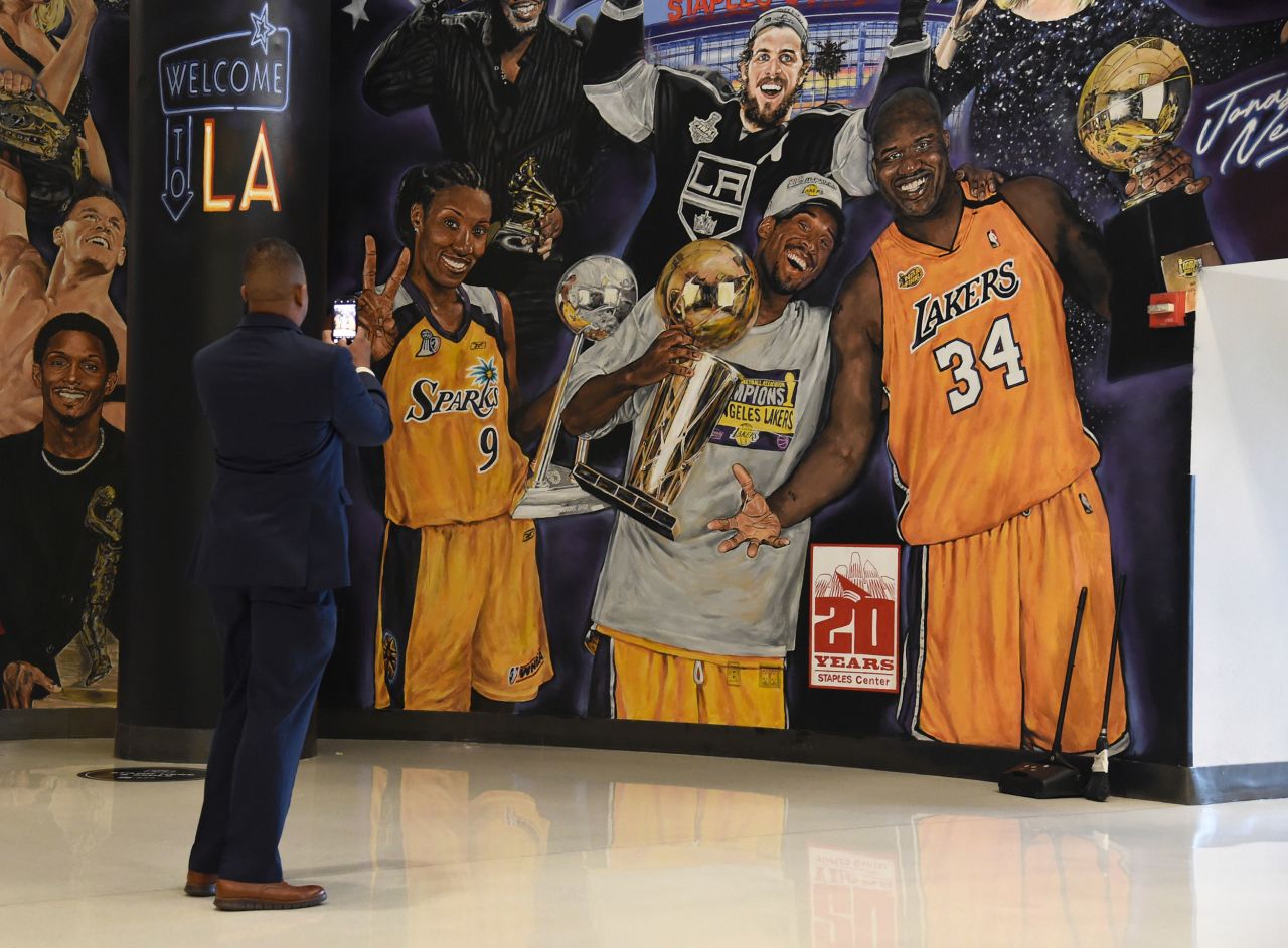 Inside the Staples Center, a man takes a photo of a mural featuring Bryant on Sunday.