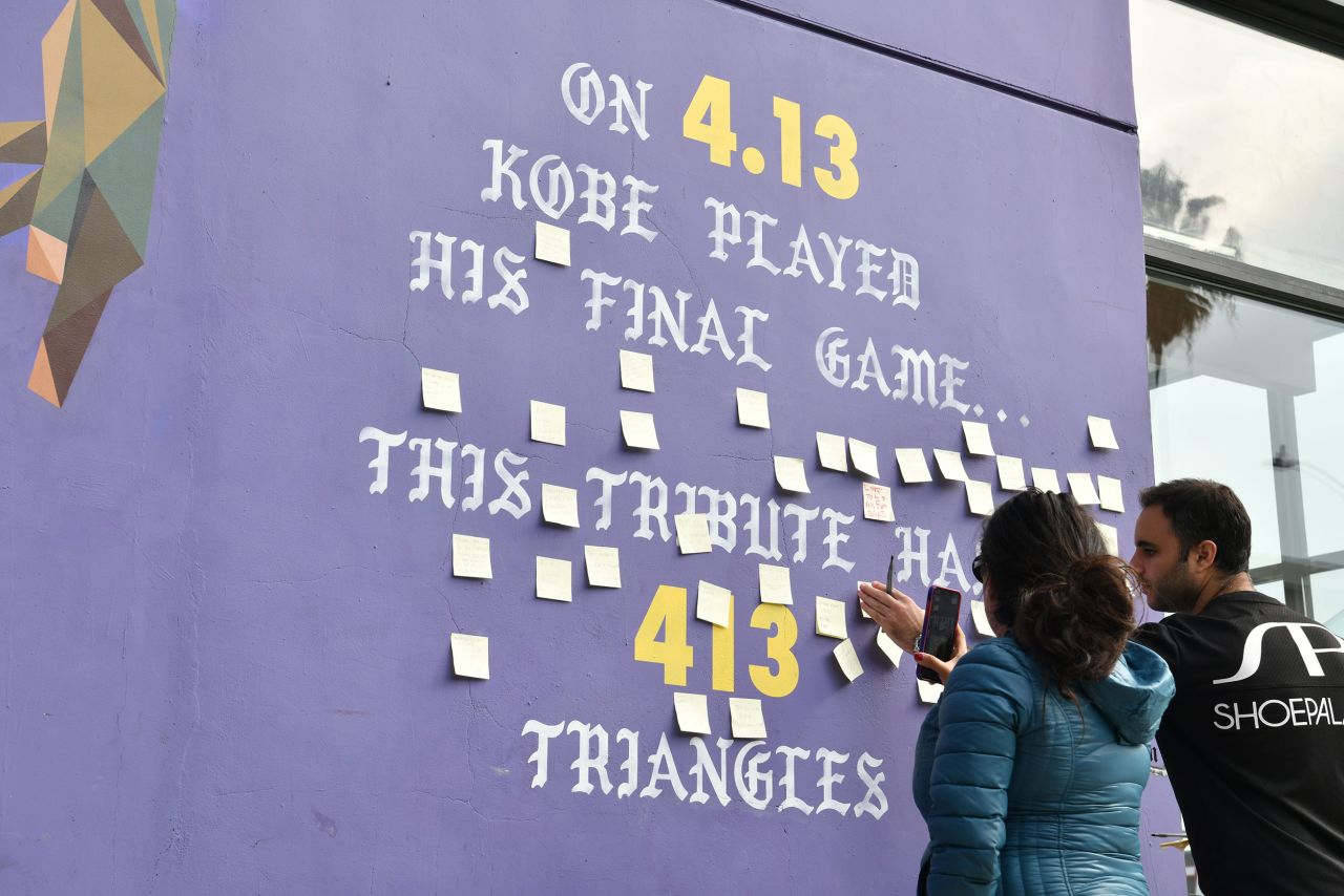 Fans are seen at a memorial started next to a mural of Bryant on Melrose Avenue in Los Angeles on Sunday.