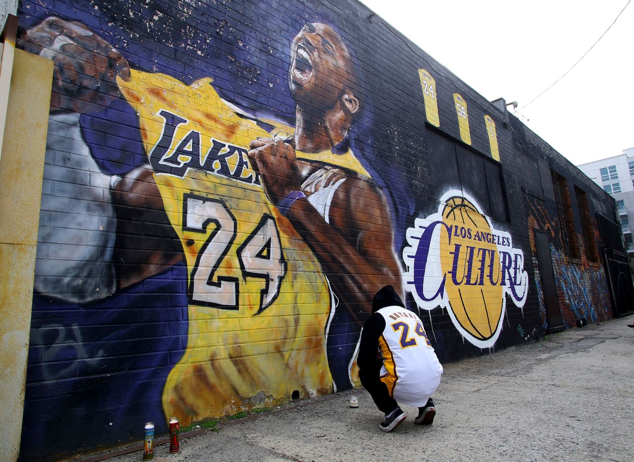 A fan pays respects at a mural depicting Bryant in downtown Los Angeles on Sunday.