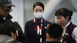 LOS ANGELES, CA - JANUARY 23: A Japan Airlines worker (C) wears a face mask while working inside a terminal at Los Angeles International Airport (LAX) on January 23, 2020 in Los Angeles, California. LAX is currently screening some incoming international passengers for a new Coronavirus which has left at least 25 dead in China and spread to multiple countries including the U.S. (Photo by Mario Tama/Getty Images)