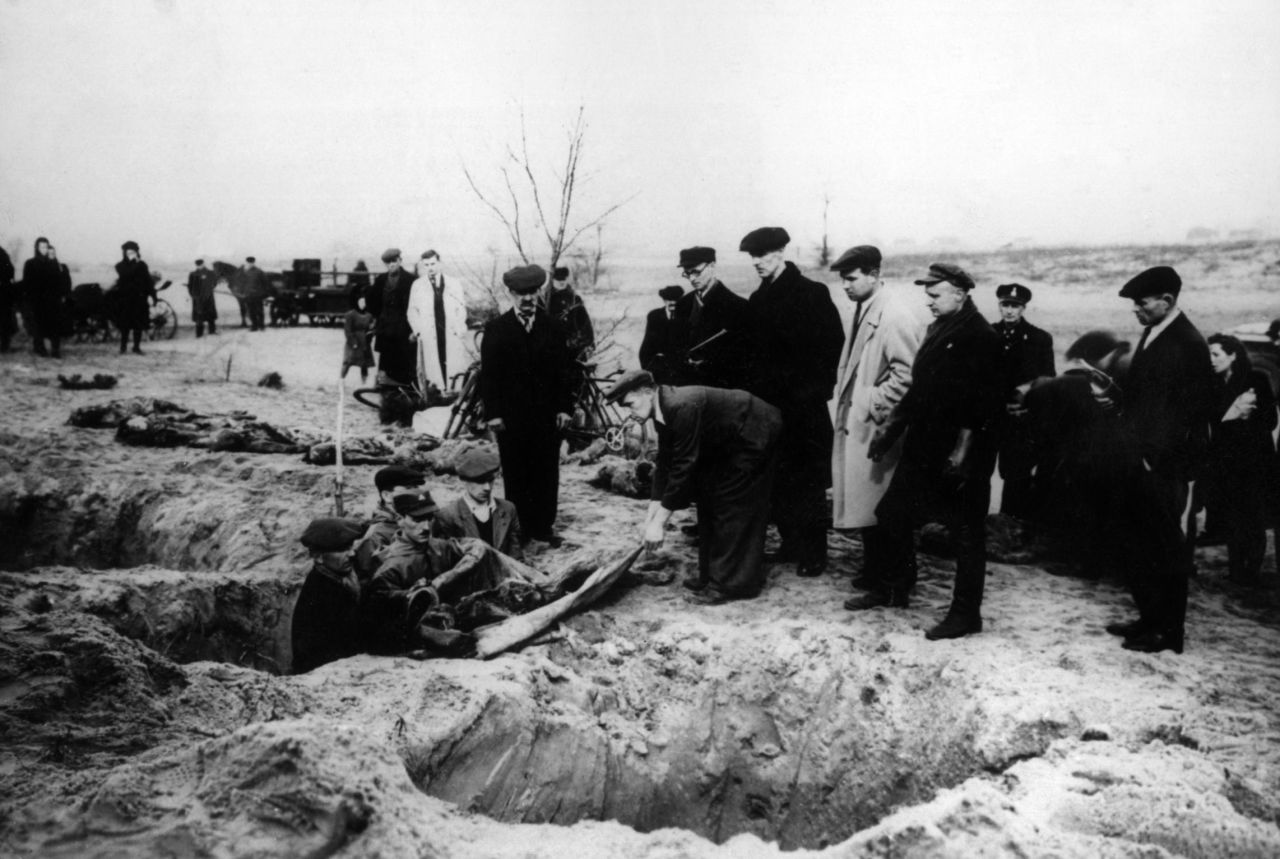 Civilians and soldiers recover corpses from common graves shortly after the liberation.