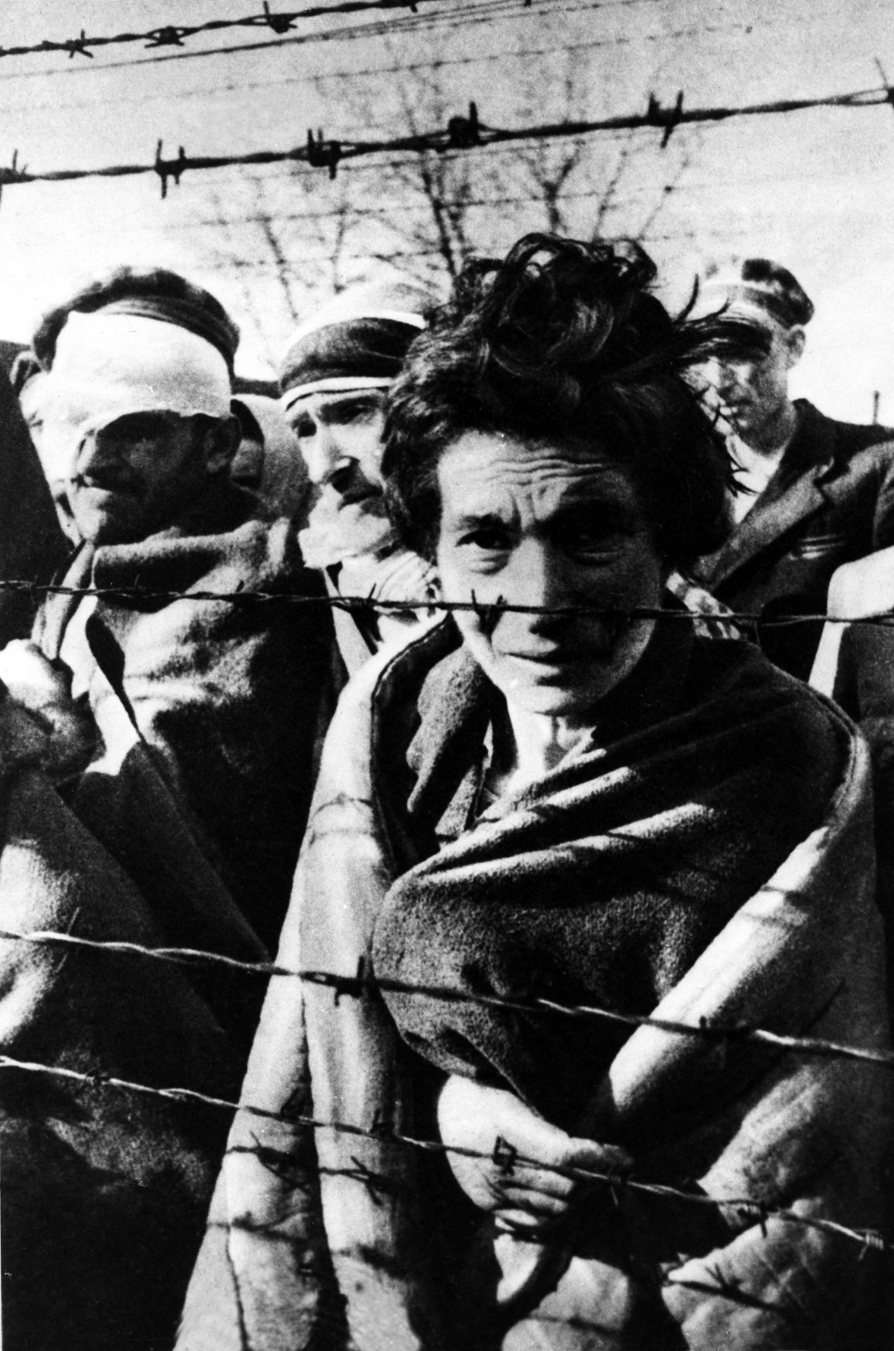 A few survivors of Auschwitz stand near the fence during the arrival of the Red Army on January 27,1945.