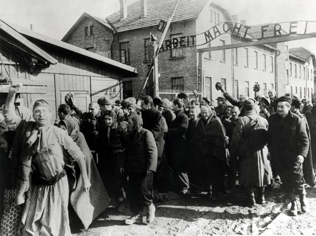 Survivors of Auschwitz leave the concentration camp at the end of World War II in February 1945. Above them is the German slogan "Arbeit macht frei," which translates to "Work sets you free."