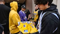 Kobe Bryant fan Anthony Bell, carrying his baby clothes, joins other fans as they gather around a small memorial at the entrance of the Mamba Sports Academy in Thousand Oaks, Calif. on Sunday Jan. 26, 2020. Retired NBA star Kobe Bryant died in a helicopter crash Sunday. He was 41. People familiar with the accident told the AP that Bryant and his 13-year-old daughter were among the victims. (AP Photo/Richard Vogel)
