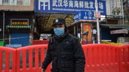 A police officer stands guard outside of Huanan Seafood Wholesale market where the coronavirus was detected in Wuhan on January 24, 2020. - The death toll in China's viral outbreak has risen to 25, with the number of confirmed cases also leaping to 830, the national health commission said. (Photo by Hector RETAMAL / AFP) (Photo by HECTOR RETAMAL/AFP via Getty Images)
