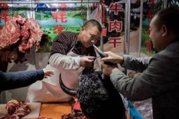 This picture taken on January 15, 2020 shows a butcher selling yak meat at a market in Beijing. 