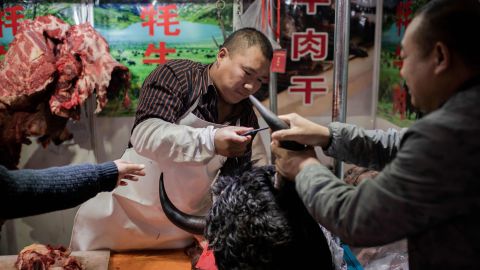 This picture taken on January 15, 2020 shows a butcher selling yak meat at a market in Beijing. 