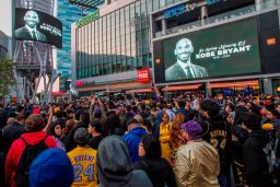 People gather around a makeshift memorial for former NBA and Los Angeles Lakers player Kobe Bryant after learning of his death, at LA Live plaza in front of Staples Center on January 26, 2020.