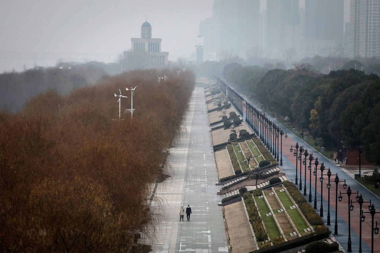 Two residents walk in an empty park in Wuhan on Janu