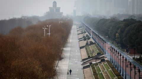 Two residents walk in an empty Jiangtan park in Wuhan, China. 