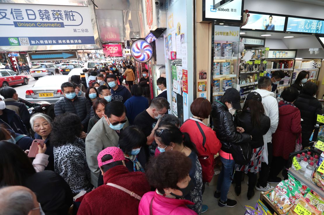 People queue for free face masks outside a cosmetics shop at Tsuen Wan in Hong Kong.