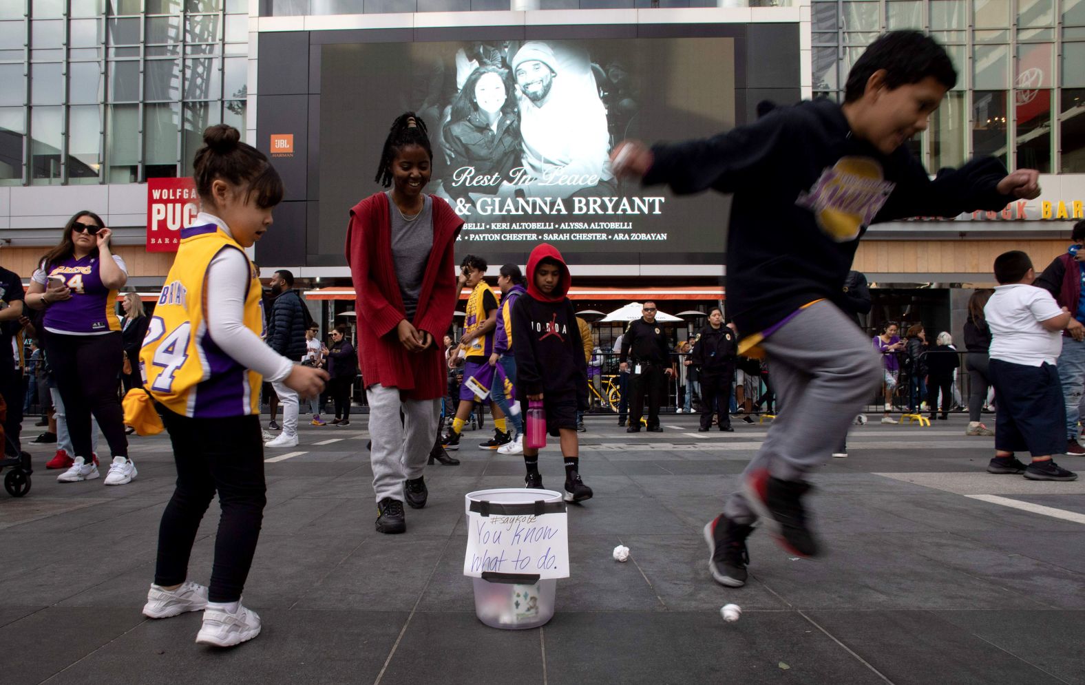 Children play with paper balls and a trash can in front of a makeshift memorial on January 27. A group of <a href="index.php?page=&url=https%3A%2F%2Fwww.cnn.com%2F2020%2F01%2F28%2Fus%2Fjumpshot-kobe-bryant-la-tribute-trnd%2Findex.html" target="_blank">fans gathered at the LA Live Plaza</a> and took turns shooting paper balls into the trash can while yelling "Kobe," a gesture practiced in classrooms and offices across America.