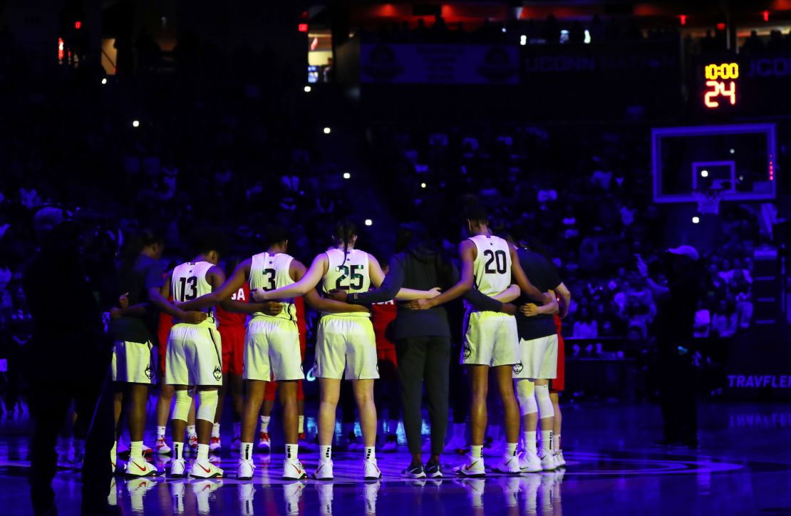 The UConn Huskies and Team USA huddle for a moment of silence in the Bryants' honor Monday. 