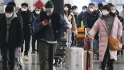 People wear masks at Beijing international airport on Jan. 27, 2020, amid the outbreak of a new pneumonia-causing coronavirus that has spread in China and overseas. 