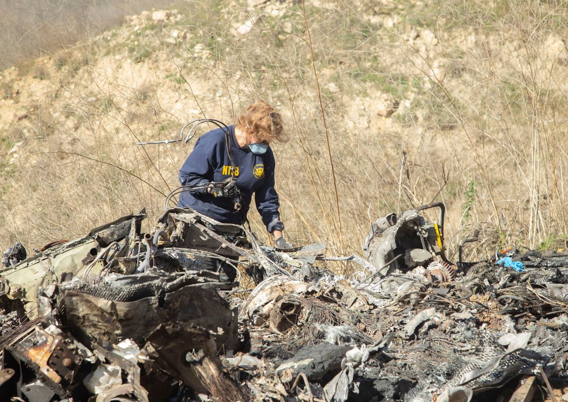 NTSB investigator Carol Hogan examines wreckage at the crash site.