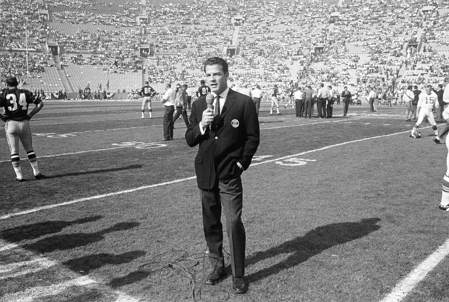 CBS commentator Frank Gifford works on the field before the game. The game was televised by both CBS and NBC. CBS held the rights to NFL games, while NBC had the rights to AFL games.