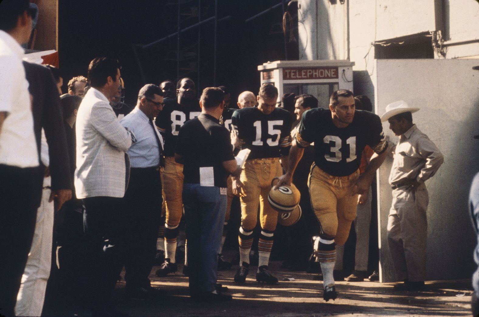 Packers fullback Jim Taylor (No. 31) leads a group of teammates out of a tunnel before the game. Behind him is Starr (No. 15). Both are now in the Pro Football Hall of Fame.