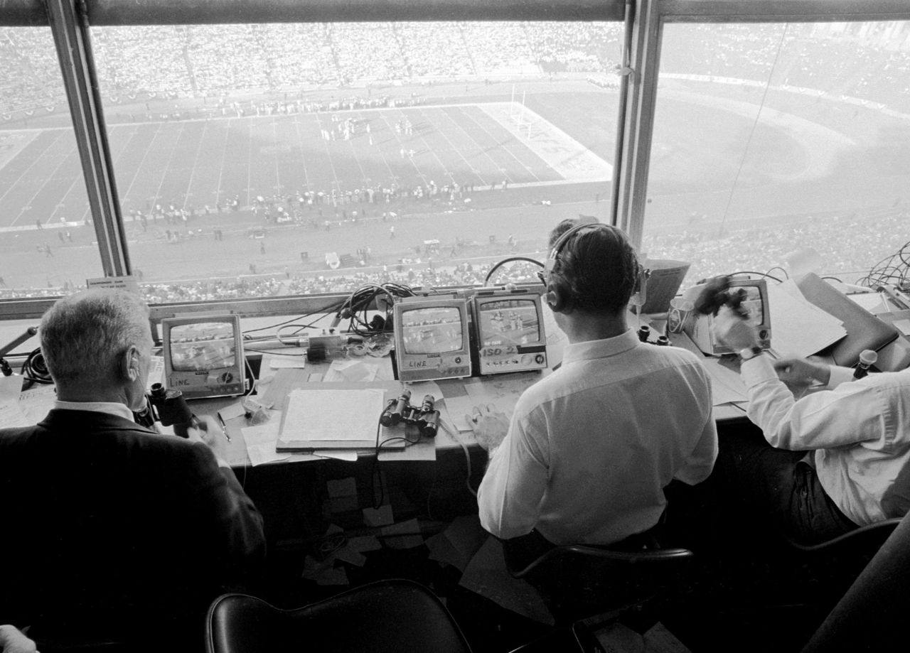 The CBS Sports team works in the press box during the game.