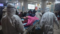 TOPSHOT - In this photo taken on January 25, 2020, medical staff wearing protective clothing to protect against a previously unknown coronavirus arrive with a patient at the Wuhan Red Cross Hospital in Wuhan. - The number of confirmed deaths from a viral outbreak in China has risen to 54, with authorities in hard-hit Hubei province on January 26 reporting 13 more fatalities and 323 new cases. (Photo by Hector RETAMAL / AFP) (Photo by HECTOR RETAMAL/AFP via Getty Images)