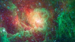 Swirling dust clouds and bright newborn stars dominate the view in this image of the "Lagoon nebula" from NASA's Spitzer Space Telescope. Also known as Messier 8 and NGC 6523, astronomers estimate it to be between 4000 and 6000 light years away, lying in the general direction of the center of our galaxy in the constellation Sagittarius.The Lagoon nebula was first noted by the astronomer Guillaume Le Gentil in 1747, and a few decades later became the 8th entry in Charles Messier's famous catalog of nebulae. It is of particular interest to stargazers as it is only one of two star-forming nebulae that can be seen with the naked eye from northern latitudes, appearing as a fuzzy grey patch.The glowing "waters" of the Lagoon, as seen in visible light, are really pools of hot gas surrounding the massive, young stars found here. Spitzer's infrared vision looks past the gas to show the dusty basin that it fills. Here we see the central regions of the Lagoon with green showing the glow of carbon-based dust grains, and red highlighting the thermal glow of the hottest dust. The various columns of dust all seem to point inwards towards the central depths of the Lagoon. These structures are being sculpted by the intense glow of giant, young stars found at the nebula's core. Within these clouds of dust and gas, a new generation of stars is forming.This image was made using data from Spitzer's Infrared Array Camera (IRAC). Blue shows infrared light with wavelengths of 3.6 microns, green represents 4.5-micron light and red, 8.0-micron light.