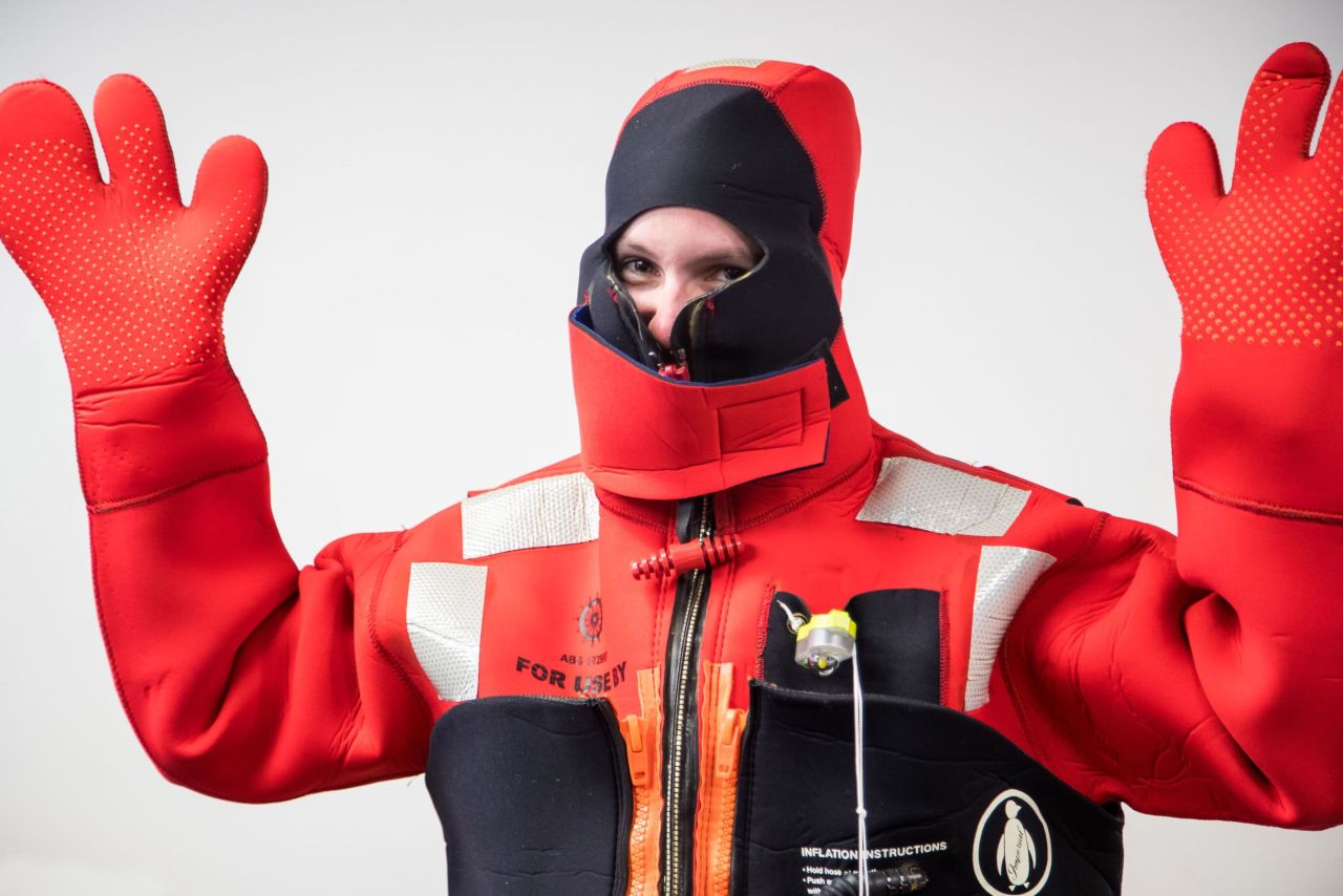Sibert demonstrating an immersion suit for use in emergency situations at sea.