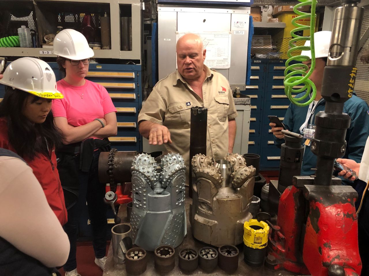 Scientists on Expedition 378 are briefed on the various drill bits used by the ship. The two larger drill bits are rotary, cutting a donut shape. Some are made of carbon steel while others are impregnated with diamonds, said Brad Clement, director of science services at the IODP.