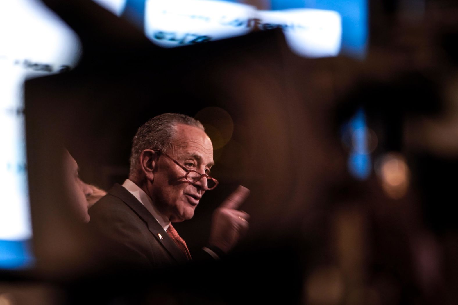 Schumer, reflected in a TV camera lens,  speaks during a news conference on January 28.