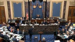 In this image from video, a Senate page brings the first question to presiding officer Chief Justice of the United States John Roberts from the majority to read during the impeachment trial against President Donald Trump in the Senate at the U.S. Capitol in Washington, Wednesday, Jan. 29, 2020. 