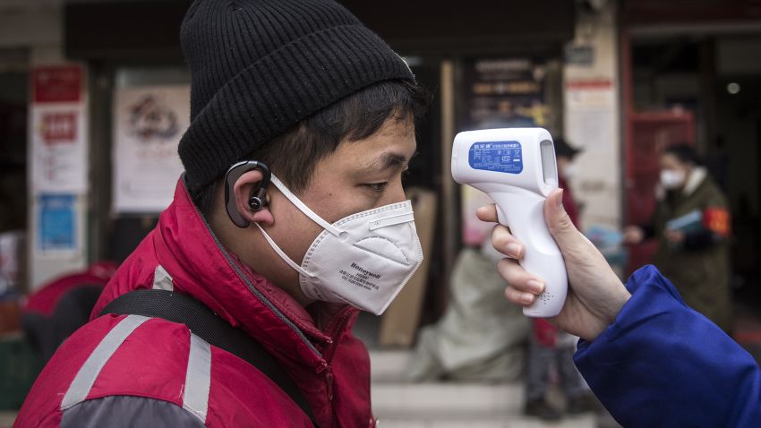 WUHAN, CHINA - JANUARY 29: (CHINA OUT)  A community worker checks the temperature of courier in an Express station on January 29, 2020 in Hubei Province, Wuhan, China. Due to a transit shut down and lack of supplies, couriers have became the city's suppliers. The 2019 coronavirus (2019-nCoV), which originated in Wuhan, China, has infected 6078 people and killed at least 132, mostly in China. (Photo by Getty Images)