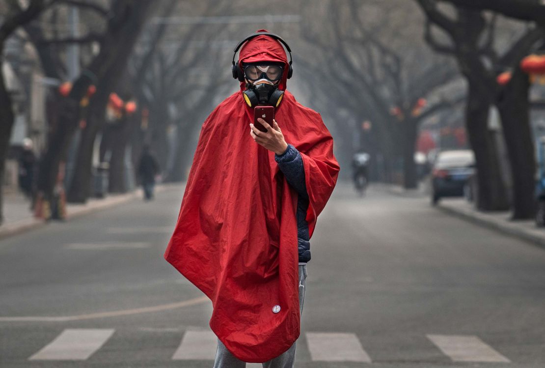 A Chinese man wears a protective mask as he stands in a nearly empty street in Beijing on January 26. 